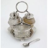 A silver plated cruet stand containing cut glass bottles comprising salt, mustard, and pepper.