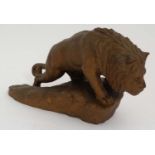 An early - mid 20thC gilded carved wooden model of a lion upon a rock.
