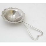 A silver tea strainer hallmarked Birmingham 1944 maker E J Houlston.