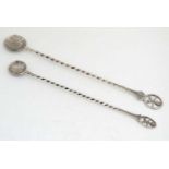 2 white metal long handled spoons with coin formed bowls and terminal to handles featuring the