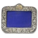 A silver photograph frame with embossed decoration. Hallmarked Chester 1900. The whole 6 1/2""