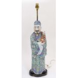 A figural Chinese ceramic table lamp depicting a robed figure holding a small child. The whole