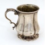 A silver mug of lobed form with engraved armorial. Hallmarked London 1828 maker James Charles