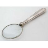 A magnifying glass with silver handle.