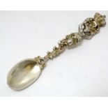 A Continental white metal spoon with scroll, caryatid and crown decoration with gilt decoration.