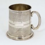 A silver mug with loop handle and engine turned decoration hallmarked Birmingham 1939 maker W I