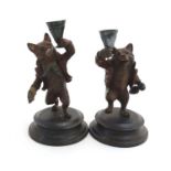 A pair of 21stC novelty cold painted bronze candlesticks depicting fox with cards and dice and bear