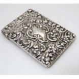 A silver card case with embossed floral and acanthus scroll decoration.