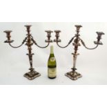 A pair of silver plate table candelabra with acanthus scroll and floral desertion .