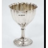 A silver pedestal egg cup with fluted decoration hallmarked Sheffield 1918 maker Atkin Brothers.