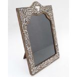 An easel back photograph frame with embossed silver surround hallmarked Birmingham 1904 maker Henry