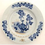 An Oriental blue and white plate decorated with birds in a flowering bough on a rocky outcrop and