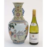A large Chinese famille rose twin handled vase, decorated with figures in a garden scene,