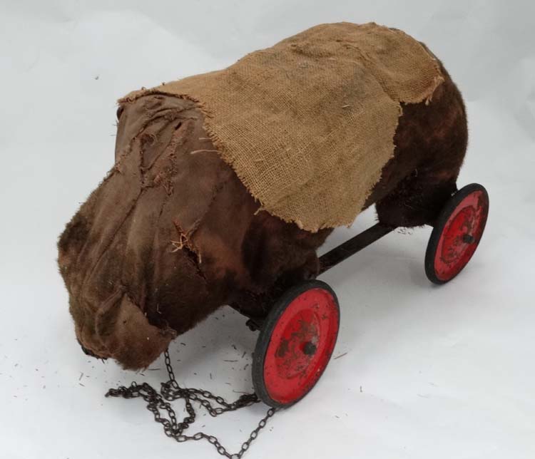 Toy: A 19th / early 20thC pull along bear, straw filled on metal base,