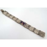 A white metal French souvenir bracelet set with various Parisian landmarks 7" long