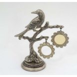 A silver plate novelty photograph frame formed as a bird in an tree with circular miniature photo