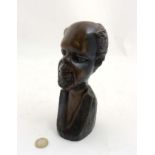 A carved wooden bust image of a bearded tribal figure , 8” high .