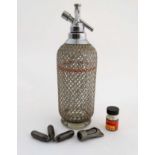 A glass soda siphon with silver plate mesh covering and mounts marked ' Sparklets Ltd.