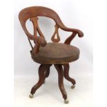 A Victorian stained fruit wood swivel circular seated office chair with 4 legs.