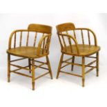 A pair of elm kitchen chairs with open arms and circular shaped backs 29" high