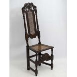 A 17thc and later carved oak high back chair with caning to back and seat.
