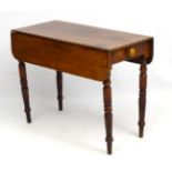 A Victorian dual drop leaf table with single long drawer to end and one opposing sham drawer,