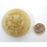 A carved mutton fat jade belt buckle formed as the head of a dragon 2 1/8" diameter