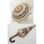 An early 20thC child's parasol with carved wooden crook handle.