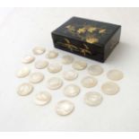 An Oriental lacquered box opening to reveal approx 20 mother of pearl gaming counters.