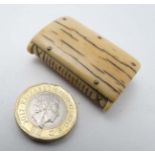 A Victorian carved ivory vesta with hinged ends and striker to spine.