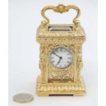 Miniature gilded carriage clock : an ornate cast case with gilded decoration on a key wind