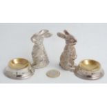 A pair of novelty silver plate table salts formed as seated rabbits before bowls. 21stC.