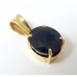A 9k gold pendant set with facet cut blue stone.