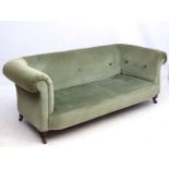 A late 19thC Chesterfield sofa with button back upholstery and buttoned arms,