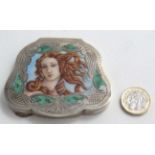 A white metal and gilt powder compact of shaped form with enamel decoration to lid,