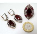 A white and gilt metal ring set with red and white stones 1 1/4" long together with a pair of