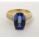 An 18ct gold ring set with central Tanzanite flanked by 3 diamonds to each shoulder