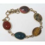 A gilt metal bracelet set with various hardstone cabochon with engraved scarab beetle decoration.