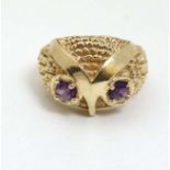 A 14ct gold ring with stylised owl head decoration with amethyst set eyes.