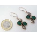 A pair of gilt and white metal drop earrings set with green and white stones.