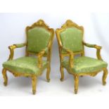 A pair of early 20thC gilt Italian open arm chairs standing on swept legs with carved toes and