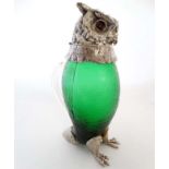 A novelty claret jug formed as an owl, having a green glass body,