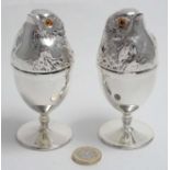 A pair of novelty silver plate egg cups and covers with chick decoration.