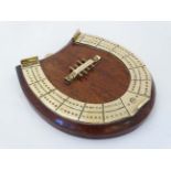 A medium brass cribbage board formed as a horseshoe,