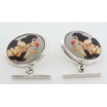 A pair of silver cufflink with risque enamel cabochon decoration depicting a woman with a rose.