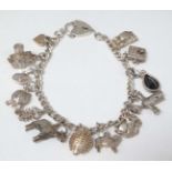 A silver charm bracelet with various silver and silver plate charms CONDITION: