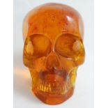 A composite amber style model of a skull. 21stC.