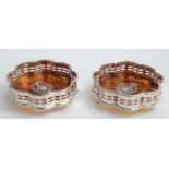 A pair of silver plate and faux tortoiseshell bottle coasters / stands.