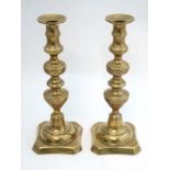 A pair of brass candlesticks with plungers.