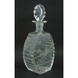 A clear cut glass decanter having etched hunting scenes to front and back and slice cut decoration